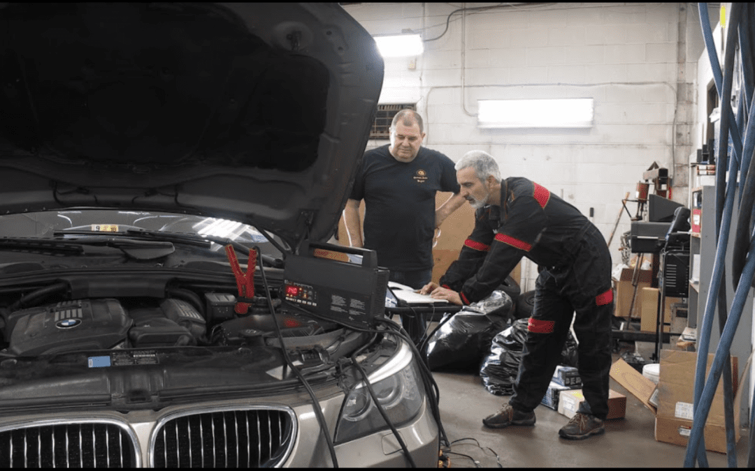 Two technicians inspecting vehicle at German Auto Repair LLC performing automobile repair Rockville MD services.